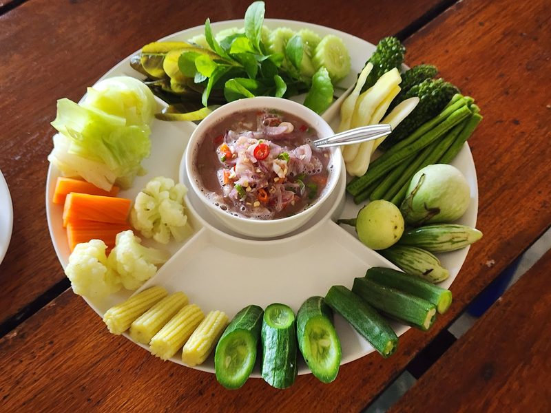 น้ำพริกถ้วยกลางจาน ล้อมด้วยผักสดหลายอย่าง